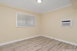 spare room featuring a wall mounted air conditioner, crown molding, and wood-type flooring