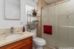 bathroom featuring vanity, toilet, and an enclosed shower