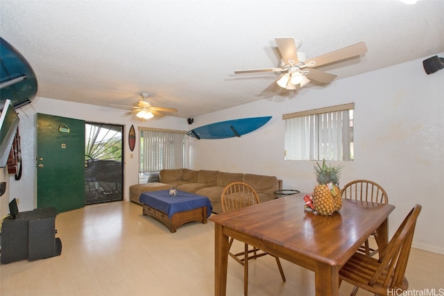 dining room with light hardwood / wood-style floors, a textured ceiling, and ceiling fan