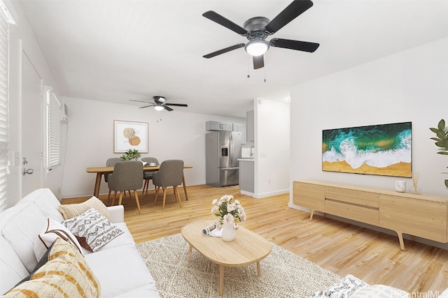 living room with ceiling fan and light hardwood / wood-style flooring