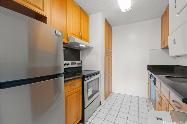 kitchen with stainless steel appliances, a textured ceiling, light tile patterned floors, and sink