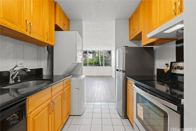 kitchen featuring black dishwasher, light tile patterned floors, stacked washer and dryer, sink, and electric range