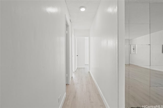 corridor with light hardwood / wood-style flooring