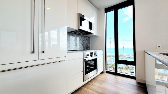 kitchen with appliances with stainless steel finishes, plenty of natural light, and modern cabinets
