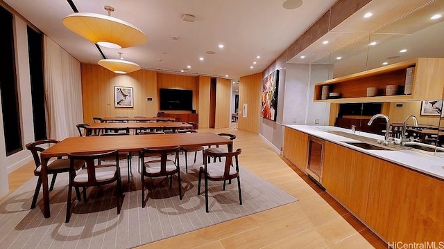dining space with recessed lighting, wood walls, and light wood-style flooring