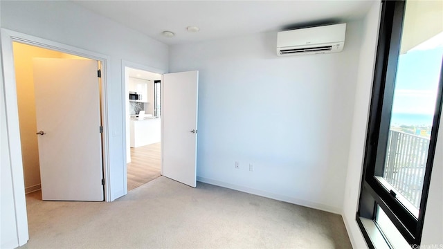 unfurnished bedroom featuring light carpet and a wall mounted air conditioner