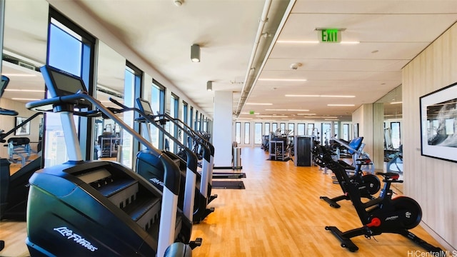 workout area with light hardwood / wood-style floors and wood walls