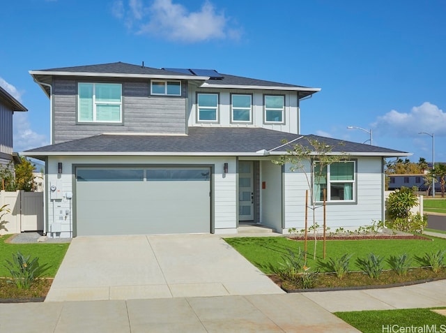 prairie-style house featuring a front lawn and a garage