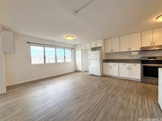 kitchen featuring stainless steel electric stove, white cabinetry, and white refrigerator