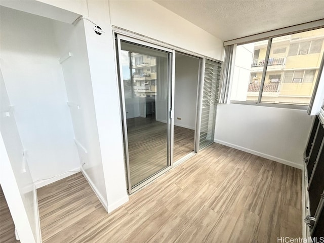 unfurnished bedroom featuring a closet, hardwood / wood-style floors, and a textured ceiling