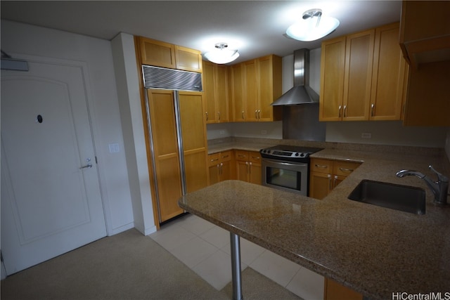 kitchen with wall chimney range hood, sink, kitchen peninsula, paneled built in fridge, and stainless steel electric range oven