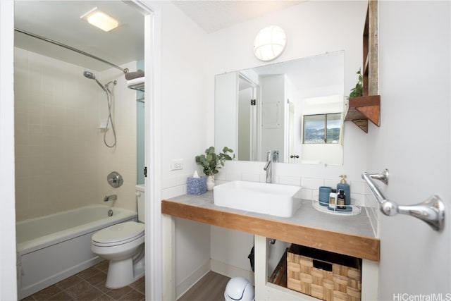 full bathroom featuring toilet, tiled shower / bath combo, and sink