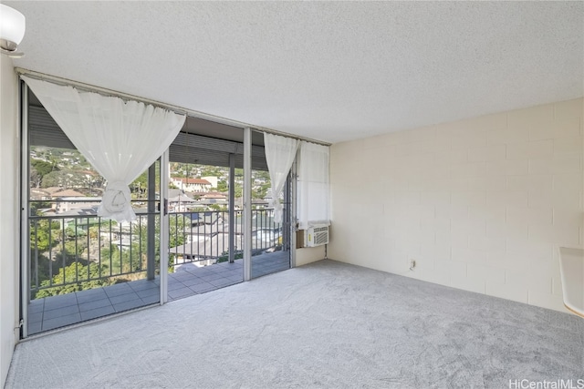 carpeted spare room featuring a textured ceiling and cooling unit