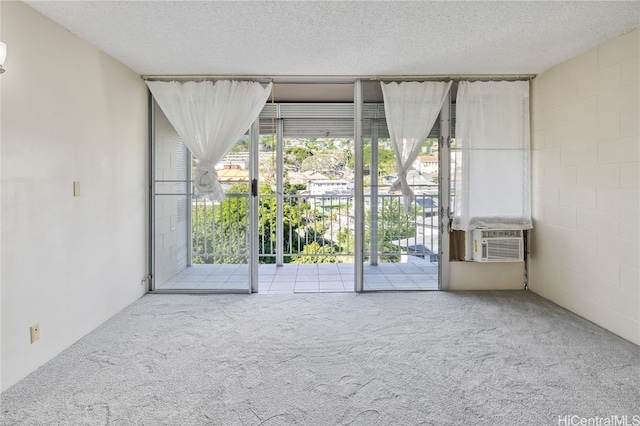 carpeted spare room featuring cooling unit and a textured ceiling