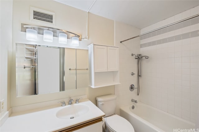 full bathroom featuring vanity, tiled shower / bath combo, and toilet