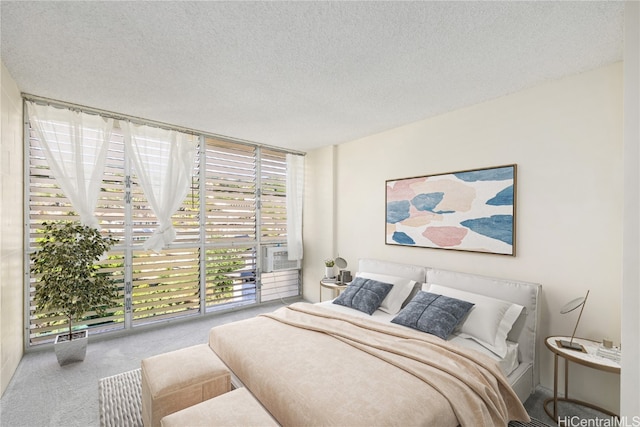 bedroom with a textured ceiling and light colored carpet