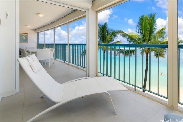 sunroom featuring a water view