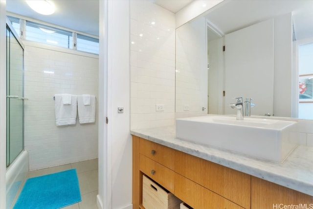 bathroom featuring vanity, enclosed tub / shower combo, and tile patterned flooring