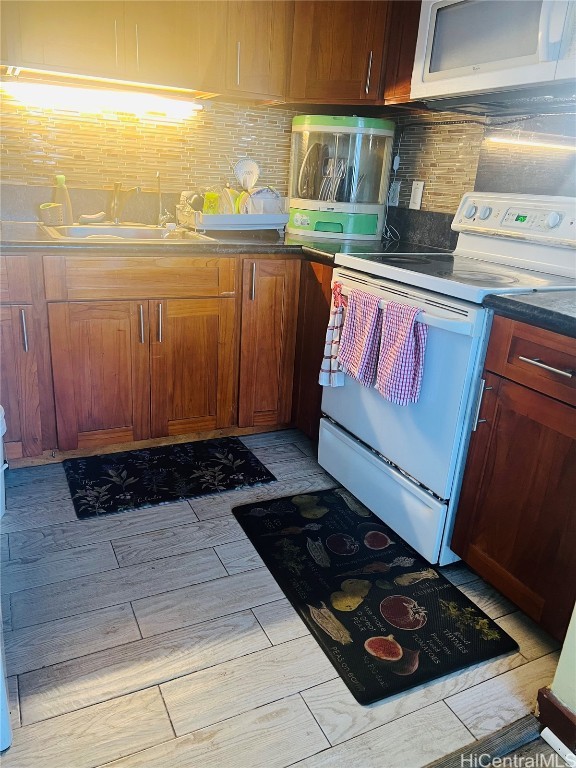 kitchen featuring light hardwood / wood-style flooring, decorative backsplash, sink, and white appliances