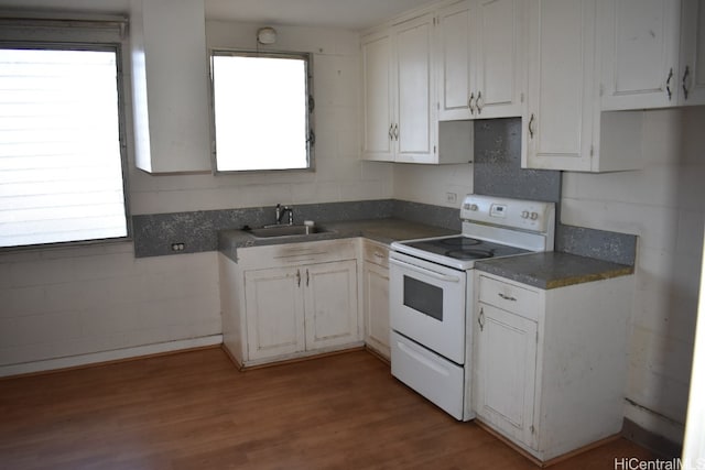 kitchen with a wealth of natural light, electric range, and white cabinetry