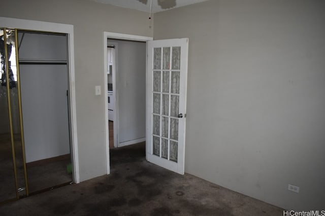 unfurnished bedroom featuring a closet and dark colored carpet