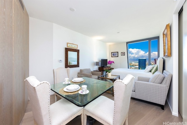 dining space featuring hardwood / wood-style flooring and a wall of windows