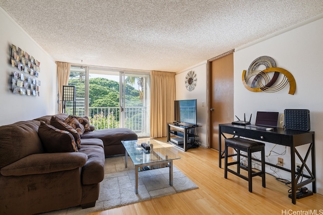 living room with a textured ceiling, ornamental molding, and hardwood / wood-style floors