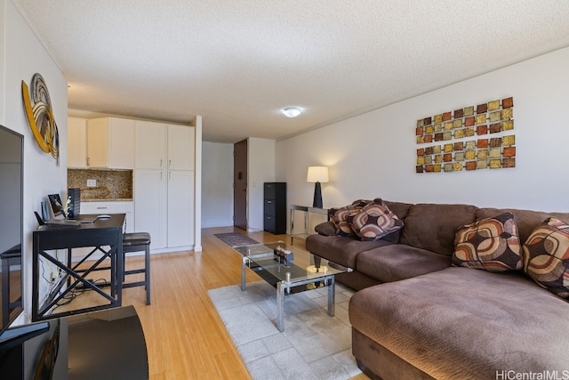 living room featuring a textured ceiling and light wood-type flooring