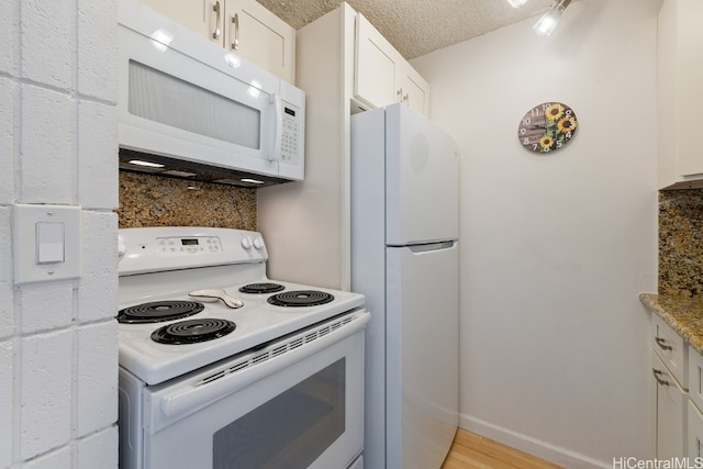 kitchen featuring light wood-type flooring, white cabinetry, a textured ceiling, and white appliances