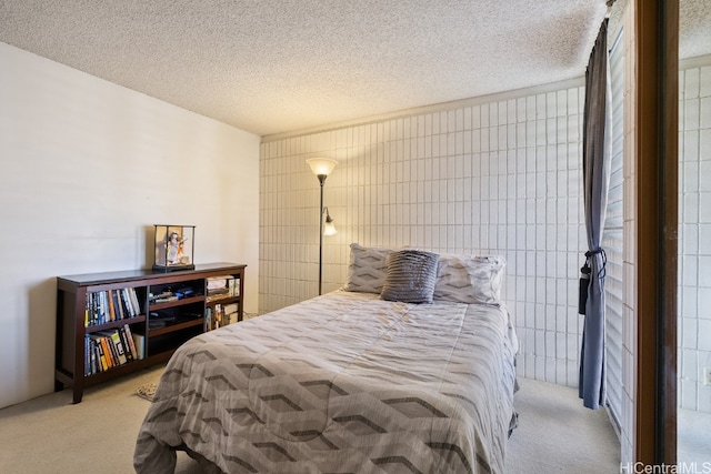 bedroom with tile walls, a textured ceiling, and light colored carpet