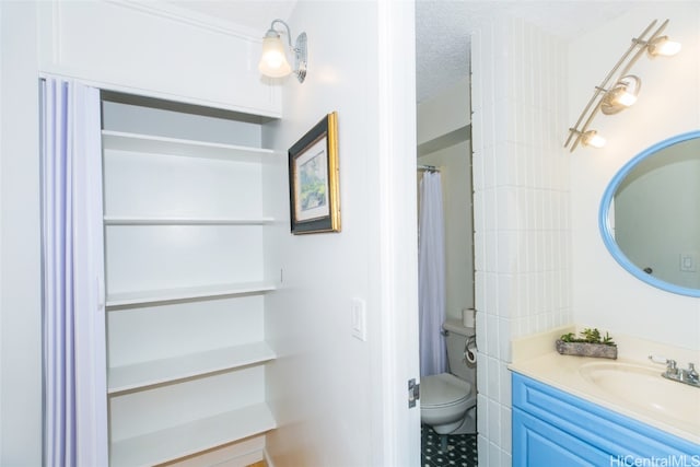 bathroom with vanity, a textured ceiling, and toilet