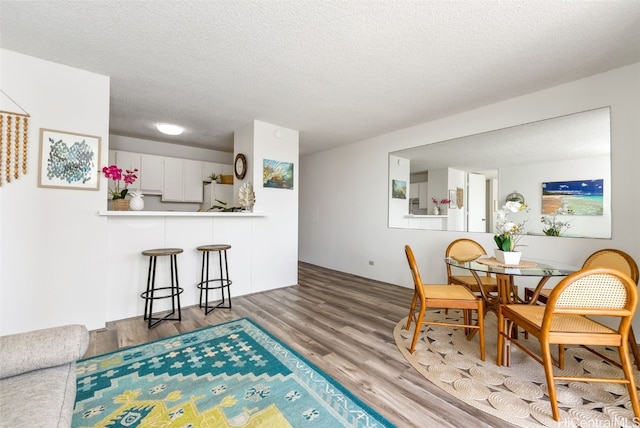 dining area featuring a textured ceiling and hardwood / wood-style flooring