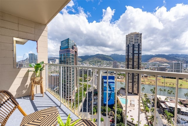 balcony featuring a water and mountain view