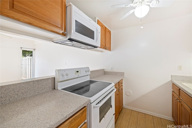 kitchen featuring ceiling fan, light hardwood / wood-style floors, and white appliances