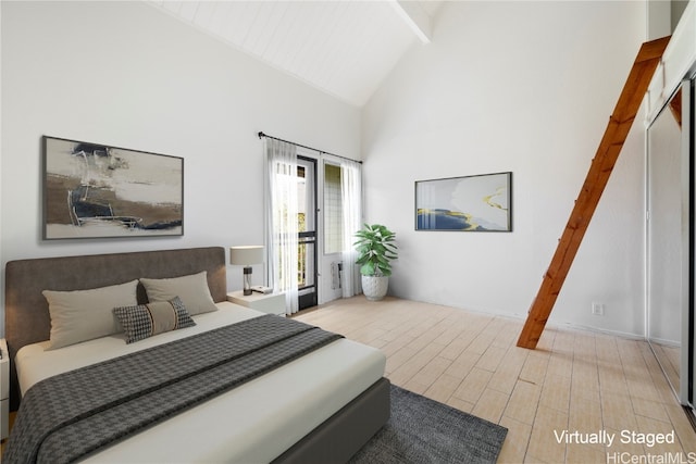 bedroom featuring beamed ceiling, light wood-type flooring, and high vaulted ceiling