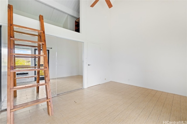 spare room featuring beam ceiling, ceiling fan, high vaulted ceiling, and light hardwood / wood-style floors