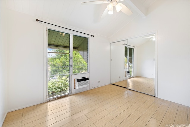 empty room featuring vaulted ceiling with beams, light hardwood / wood-style floors, a wall mounted AC, and ceiling fan