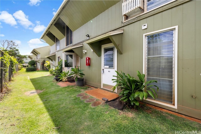 doorway to property featuring a balcony and a lawn