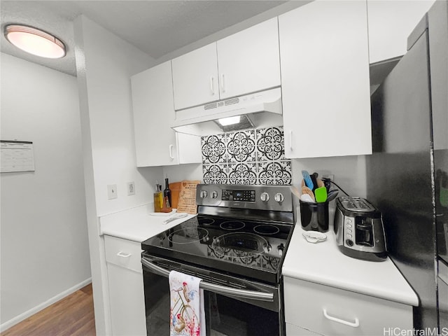 kitchen with white cabinetry, stainless steel electric range oven, and hardwood / wood-style floors