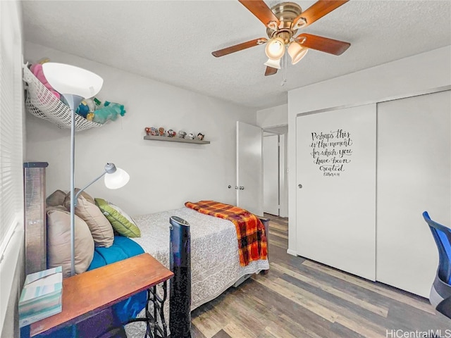 bedroom with hardwood / wood-style floors, a textured ceiling, a closet, and ceiling fan