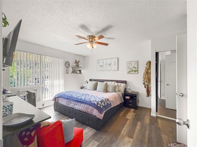 bedroom with a textured ceiling, a closet, ceiling fan, and dark wood-type flooring