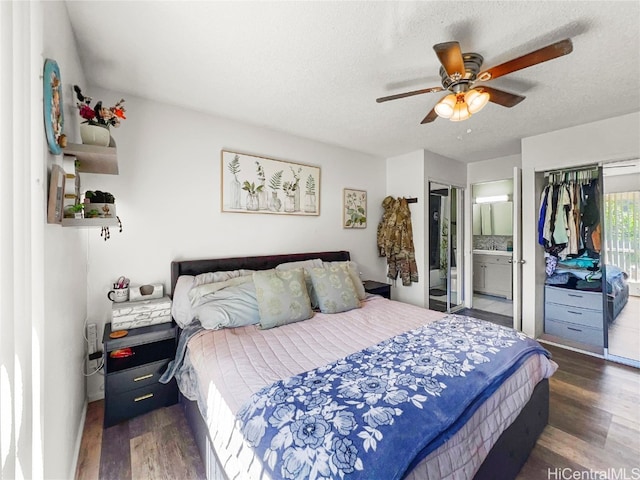 bedroom with ensuite bath, a textured ceiling, ceiling fan, dark hardwood / wood-style floors, and a closet