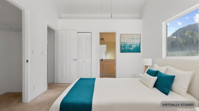 bedroom featuring light carpet and ensuite bath