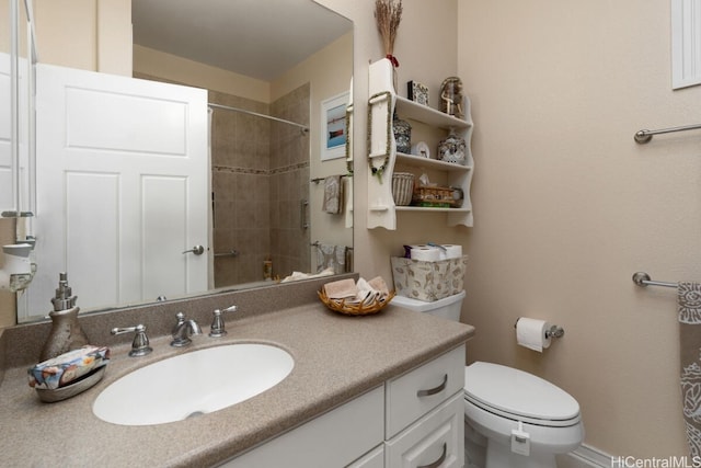 bathroom featuring vanity, a tile shower, and toilet