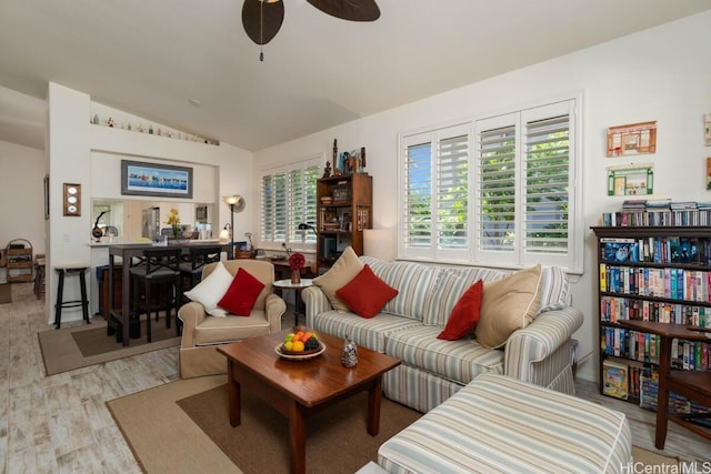 living room featuring light hardwood / wood-style floors, vaulted ceiling, plenty of natural light, and ceiling fan