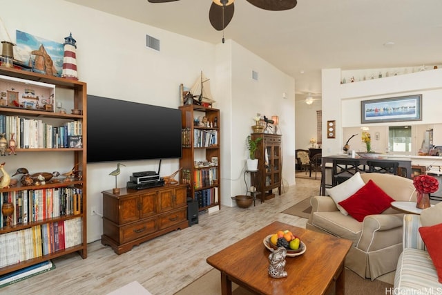 living room featuring lofted ceiling, light hardwood / wood-style flooring, and ceiling fan