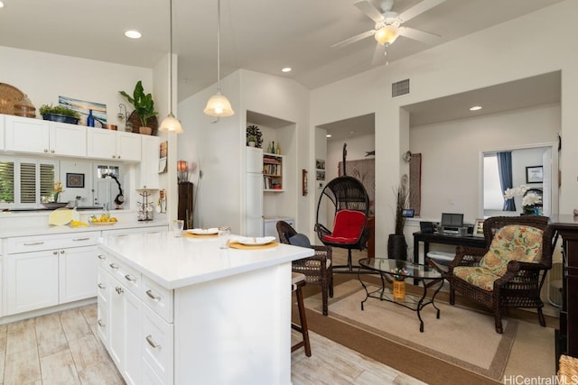 kitchen with hanging light fixtures, white refrigerator, white cabinetry, light hardwood / wood-style floors, and ceiling fan