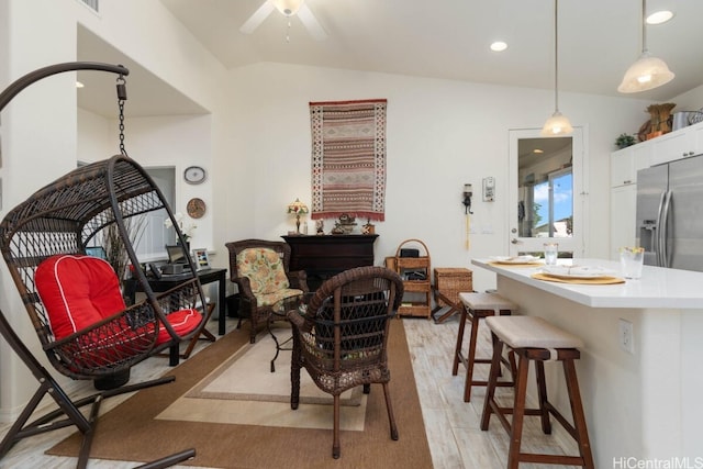 living area with vaulted ceiling and light hardwood / wood-style floors