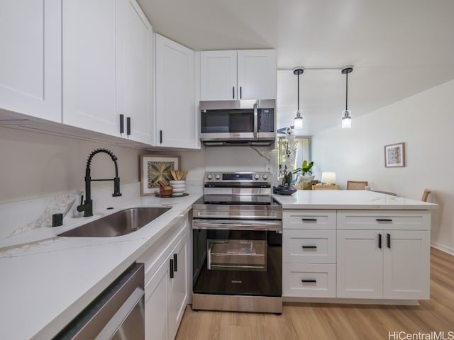 kitchen with appliances with stainless steel finishes, white cabinetry, light wood-type flooring, decorative light fixtures, and sink