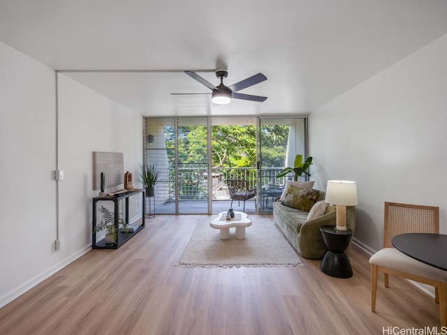 living room featuring ceiling fan, light wood-type flooring, and floor to ceiling windows